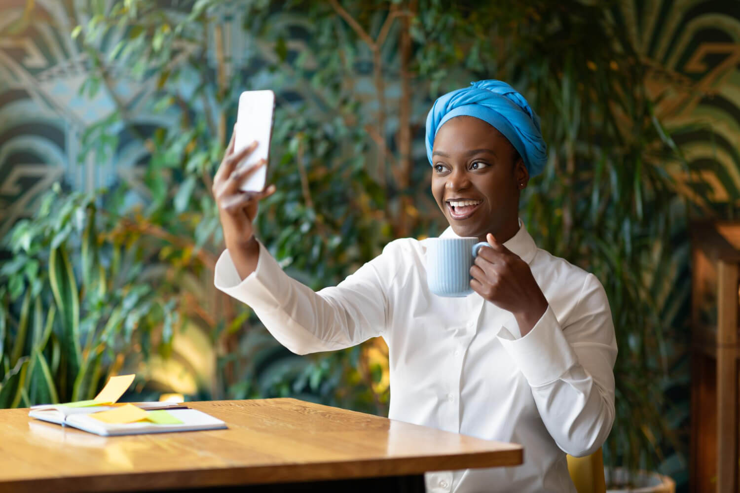 cheerful-pretty-young-black-woman-sitting-cafe-taking-selfie-1